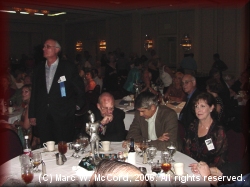 Danny Hammontree listens to announcements while Woody and Judy Bryant Thompson converse with Richard Burton